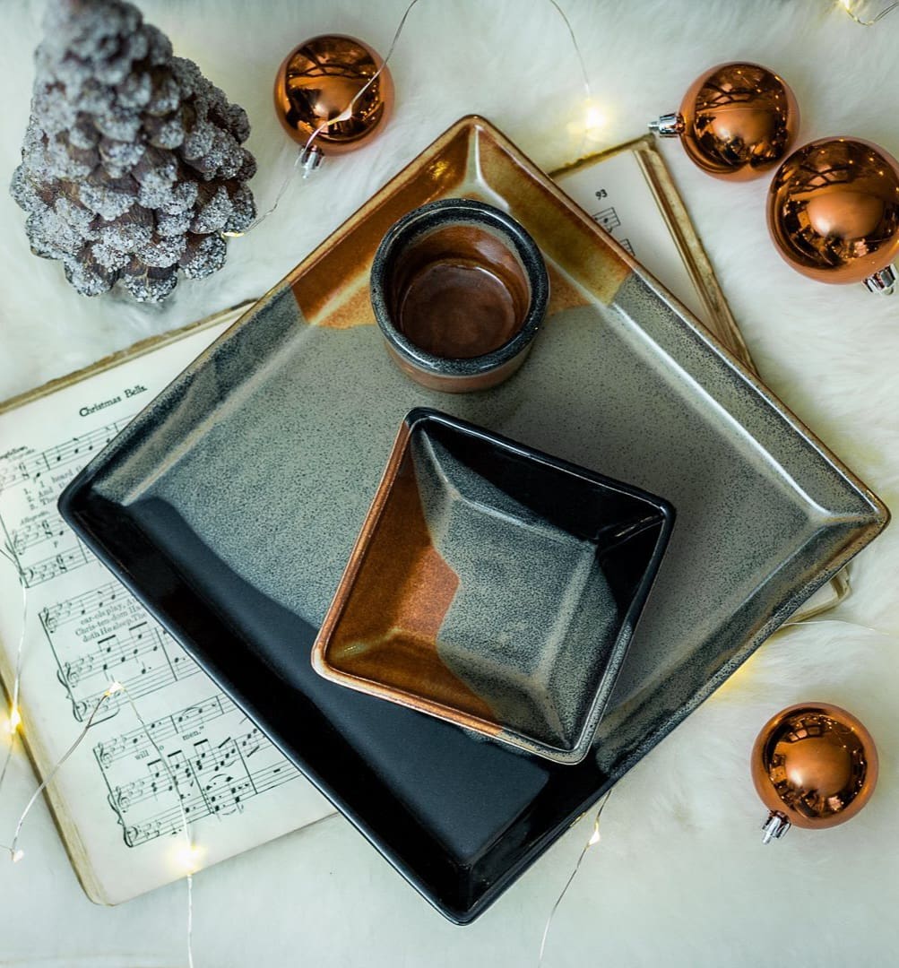 A table with some silver trays and christmas ornaments